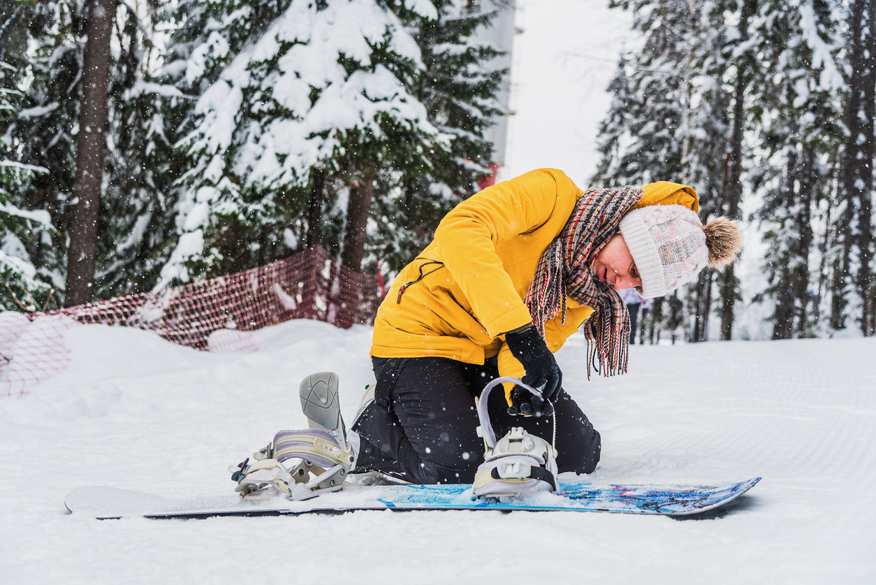woman maintaining her skis - adjusting bindings